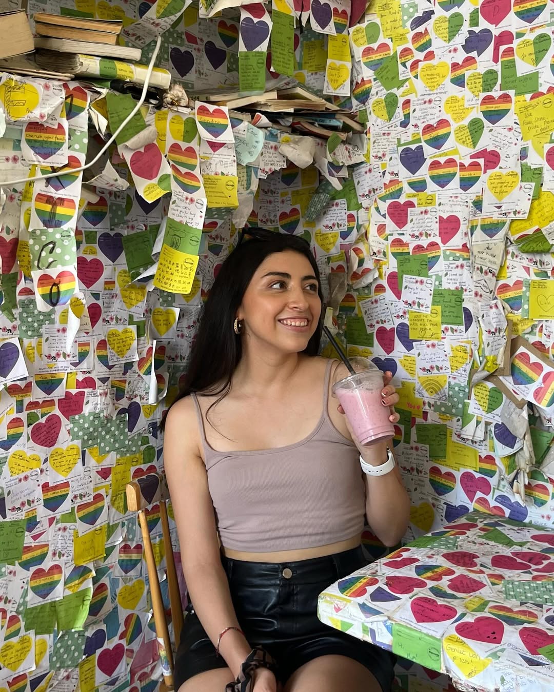 Bárbara at Note Coffee in Hanoi with smoothie, surrounded by rainbow heart notes