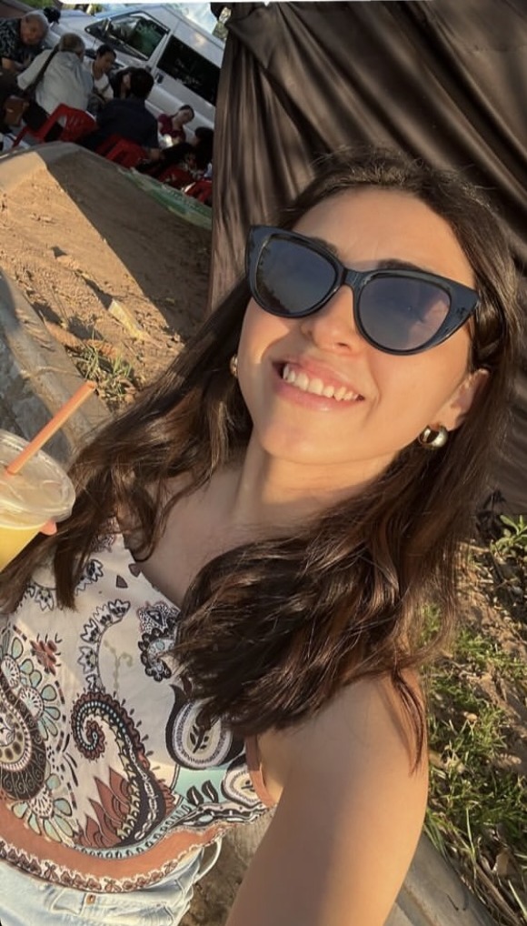 Bárbara smiling with a drink at sunset in Vietnam