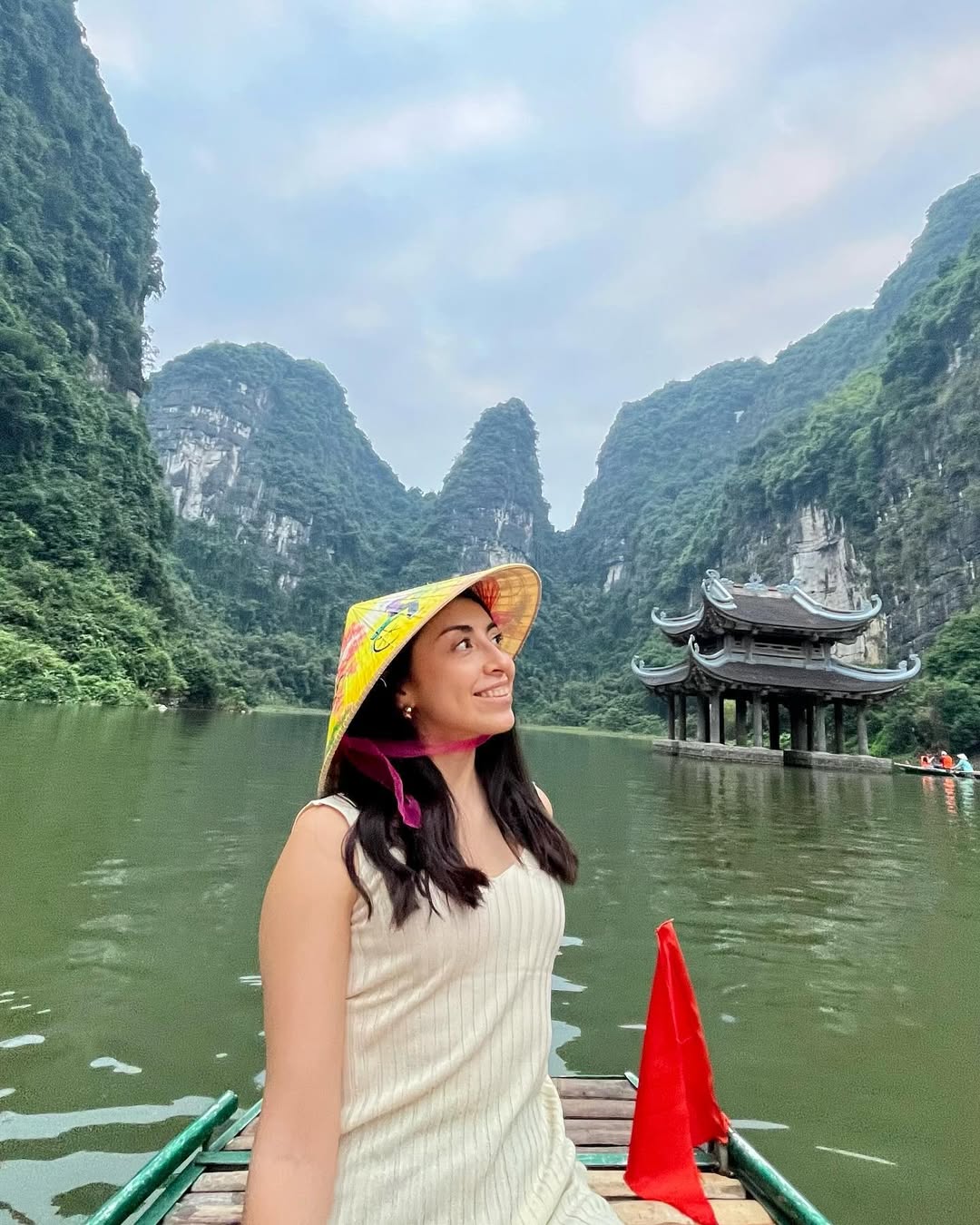 Bárbara in conical hat on boat at Trang An, Ninh Binh