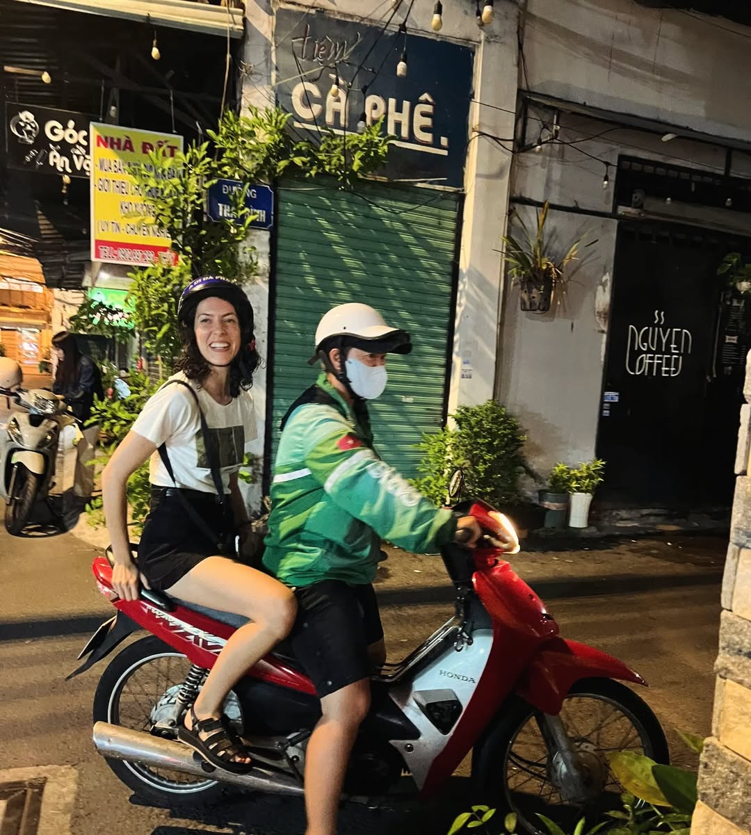 Camila riding a motorbike through Ho Chi Minh City at night