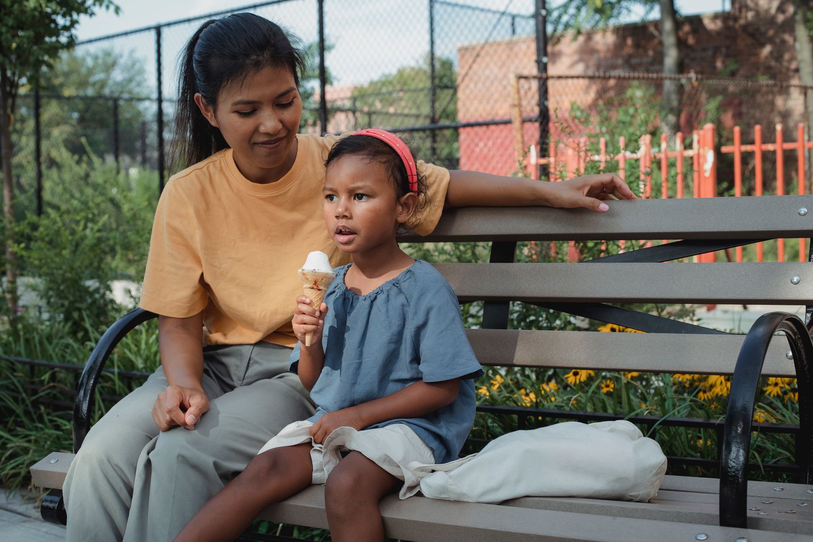 A mother and her young child sitting together outdoors
