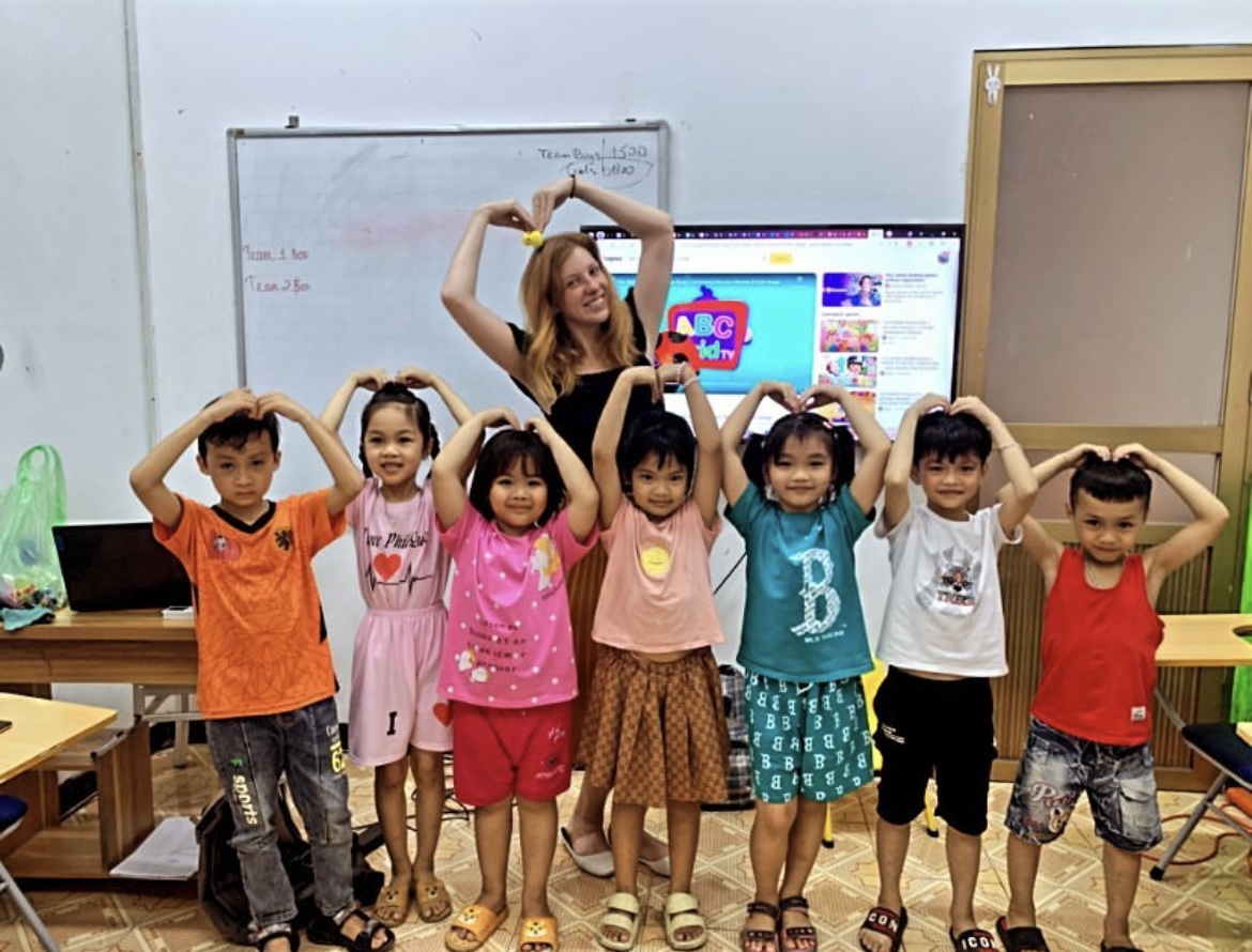Ksenia teaching a kindergarten class in Hanoi — kids making heart shapes