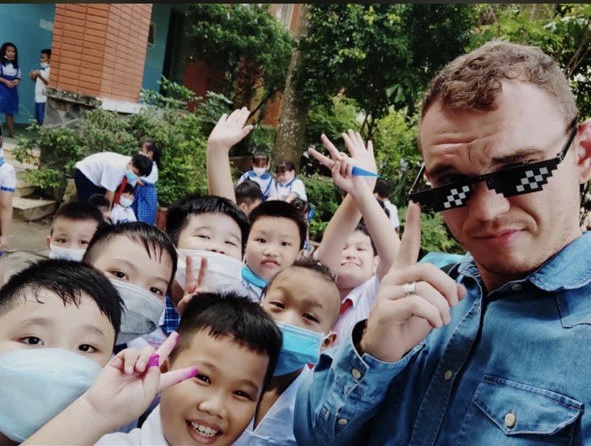 Non-native English teacher with Vietnamese students outside school